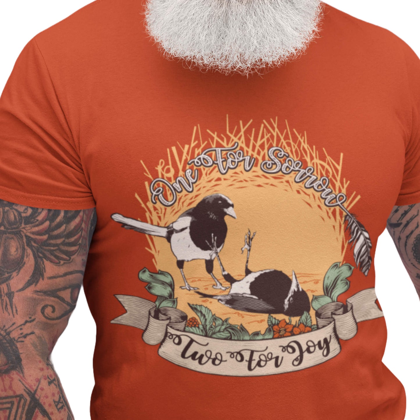 Paprika-red T-shirt featuring a dark reimagining of the “One for Sorrow, Two for Joy” nursery rhyme with illustrated magpies and a vintage folk-art aesthetic.
